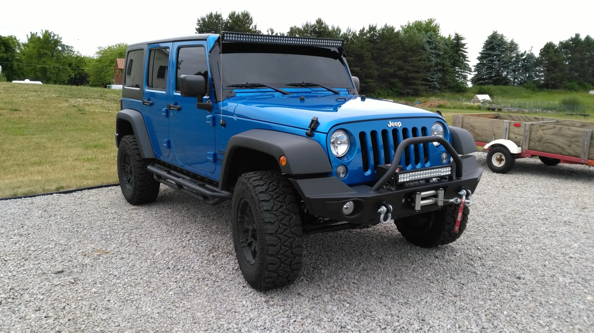 Blue Jeep Wrangler with tinted windows after installation