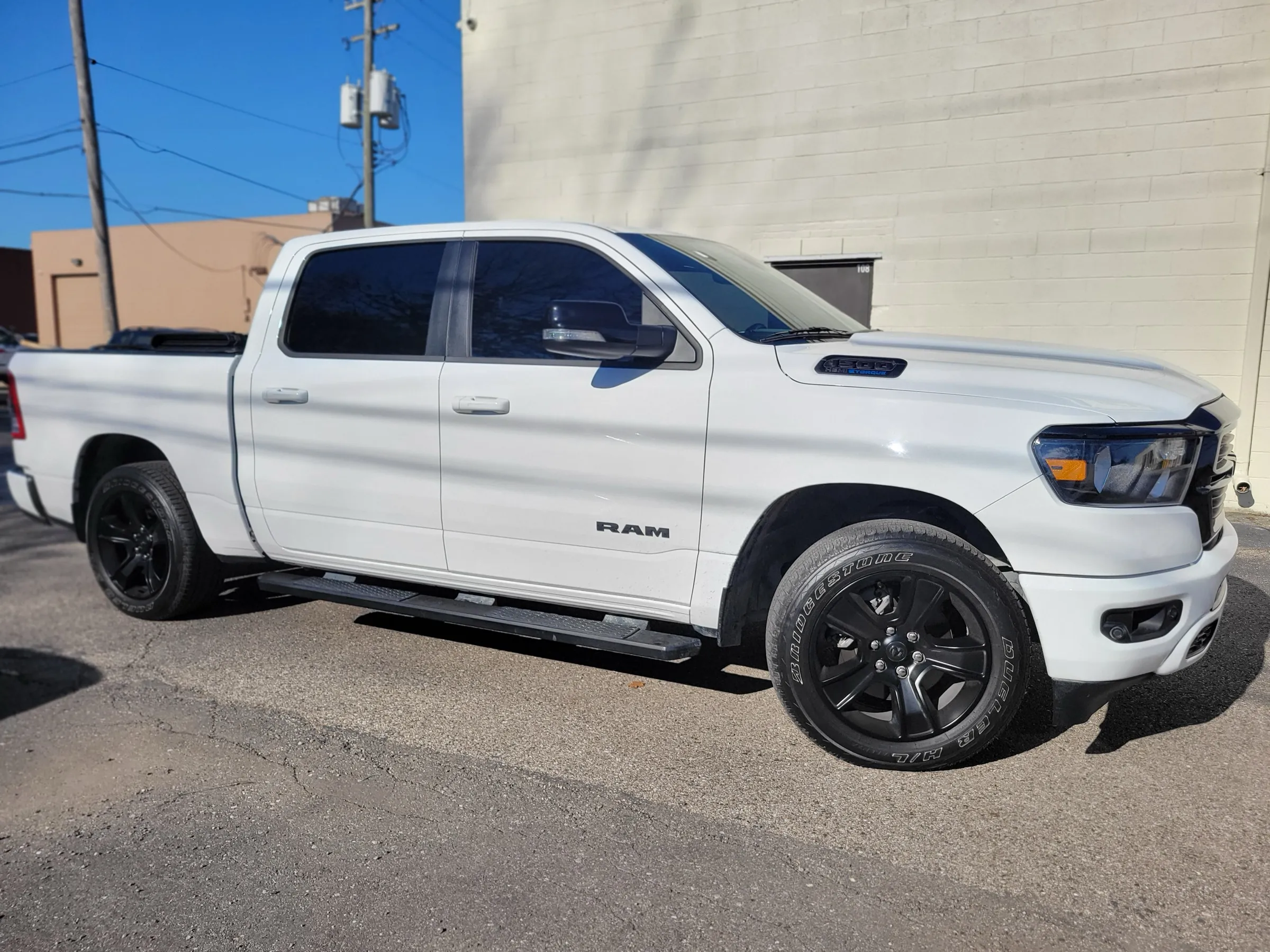 White RAM 1500 with freshly tinted windows outside the studio